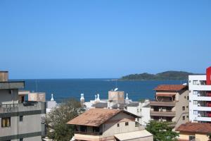 a group of buildings with the ocean in the background at Pousada Pingo d' Água in Bombinhas