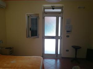 una camera con una porta, una finestra e un letto di Il Mare di Elea ad Ascea