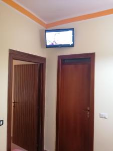una TV a schermo piatto sopra due porte in una camera di Il Mare di Elea ad Ascea