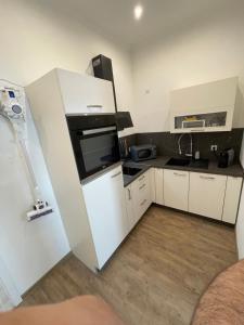 een kleine keuken met witte kasten en een koelkast bij Apartment in Mayen Zentrum nur 100 Meter in Mayen