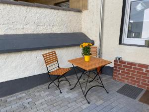 einen Tisch und zwei Stühle mit einer Blumenvase in der Unterkunft Apartment in Mayen Zentrum nur 100 Meter in Mayen