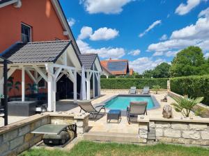 a swimming pool with a patio and a house at Ferienwohnung am Rande von Dresden in Kesselsdorf