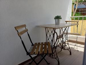una silla de madera sentada junto a una mesa con una planta en Casa Manel d'Anita, 
