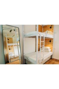 2 łóżka piętrowe w pokoju z lustrem w obiekcie Gia Dormitory w Tel Awiwie
