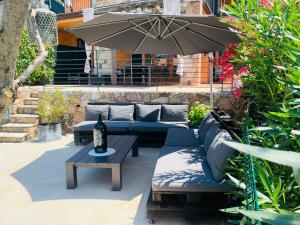 een patio met een bank en een tafel met een parasol bij Appartamento di Felice in Castion Veronese