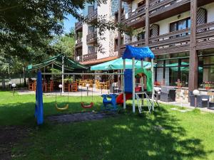 a playground in a park in front of a building at Hotel Orphey in Bansko
