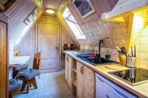uma cozinha com um tecto de madeira e um lavatório em Aparthotel Pod Nosalem em Zakopane