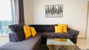 - un salon avec un canapé brun et des oreillers jaunes dans l'établissement Luxury Apartment with Pool, à Martil