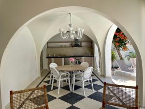 una sala da pranzo con tavolo e sedie di Byblos Aria-The Sea Side Luxury Villa a Skala Sotiros