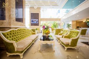a living room with green couches and a table at Putin Hotel Nha Trang in Nha Trang