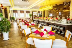 a restaurant with tables and chairs with red napkins at Putin Hotel Nha Trang in Nha Trang