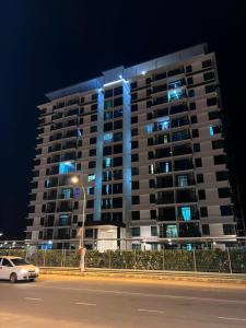 a tall building with blue lights on it at night at Ab’s Benoni Suites in Papar