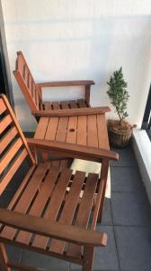 a wooden bench and a table and a potted plant at Ab’s Benoni Suites in Papar