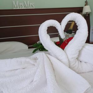アギア・ガリニにあるAvraのベッドの上に座ってタオルを2枚