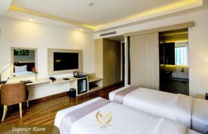 a hotel room with two beds and a television at Putin Hotel Nha Trang in Nha Trang