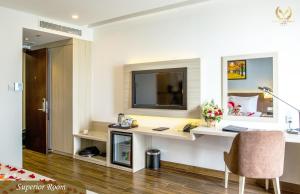 a room with a desk and a television on a wall at Putin Hotel Nha Trang in Nha Trang
