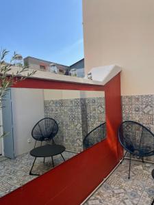 three chairs sitting on a balcony with tiles at Les Apparts de la Bastide 35A in Villeneuve-sur-Lot