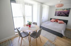 a bedroom with a bed and a table and chairs at Seaside apartment Albatross, spa and pool in Ķesterciems