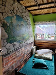 two beds in a room with a stone wall at Wynajem Pokoi Krystyna Mróz in Zakopane