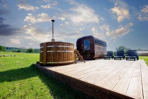 una terraza de madera con un barril y sillas en un campo en Agroturystyka ''Relax'', en Chęciny