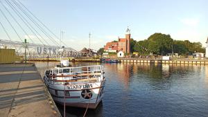 a boat is docked in the water next to a dock at Ustka Na Wydmie in Ustka