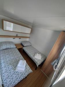 a small room with two beds and a chair at Philomena Mobile home Camping Pasman in Pašman
