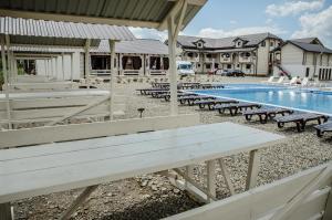 a row of picnic tables next to a swimming pool at Сонячна in Solotvyno