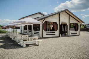 a building with benches and umbrellas in front of it at Сонячна in Solotvyno