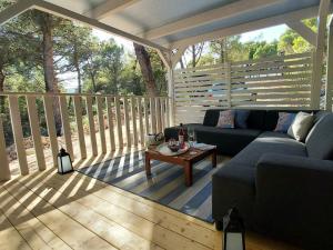 a living room with a couch and a table on a deck at Philomena Mobile home Camping Pasman in Pašman