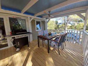 a patio with a table and chairs on a deck at Philomena Mobile home Camping Pasman in Pašman