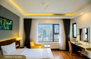 a hotel room with a bed and a desk and a window at Putin Hotel Nha Trang in Nha Trang