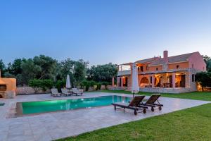 a backyard with a swimming pool and a house at Ionian Dreams Luxurious Country Villas in Argostoli