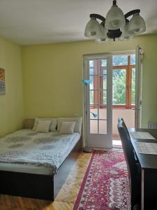a bedroom with a bed and a table and a window at Casa Marius in Braşov
