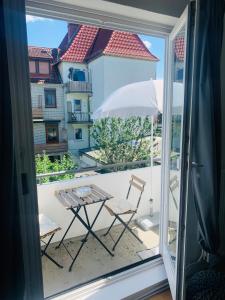 einen Balkon mit einem Tisch, Stühlen und einem Sonnenschirm in der Unterkunft Schönes 2-Zimmer-Apartment in Bremen, Findorff in Bremen