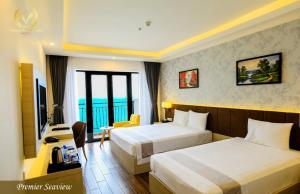 a hotel room with two beds and a desk at Putin Hotel Nha Trang in Nha Trang