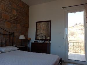 a bedroom with a bed and a brick wall at Traditional art apartment 3 in Akoumia
