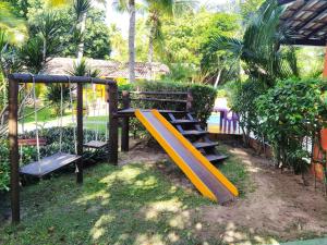 un parc avec une aire de jeux avec un toboggan dans l'établissement Pousada Canto De Imbassai, à Imbassaí