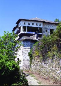 un edificio sentado en la parte superior de una pared de piedra en Santikos Mansion, en Vizítsa