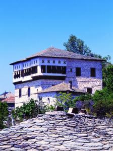un gran edificio de piedra en la parte superior de una carretera de piedra en Santikos Mansion, en Vizítsa