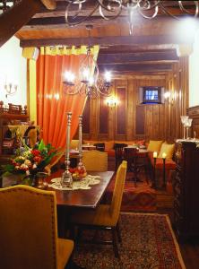 een eetkamer met een tafel en stoelen en een kroonluchter bij Santikos Mansion in Vizitsa