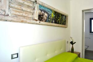 a bedroom with a bed and a painting on the wall at B&B Monteleo Salento in Morciano di Leuca