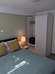 - une chambre avec un lit, un placard et une lampe dans l'établissement Cosy garden house, à Rafína