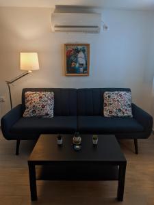 - un canapé bleu dans le salon avec une table basse dans l'établissement Cosy garden house, à Rafína