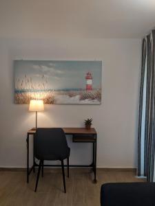 un bureau avec une lampe et une photo d'un phare dans l'établissement Cosy garden house, à Rafína