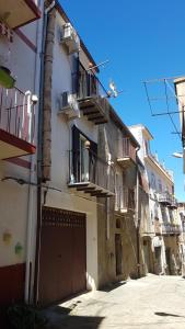 eine Gasse mit einem Gebäude mit Balkonen und einer Garage in der Unterkunft Arte Mare e Cultura in Pettineo