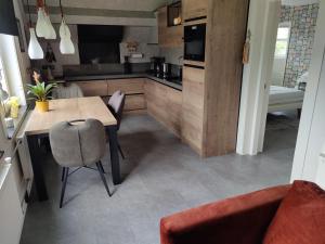 uma cozinha com uma mesa de madeira e uma sala de jantar em Holiday home Jong em Schagerbrug