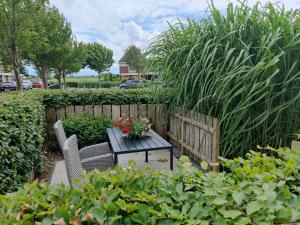 een tafel en stoelen in een tuin met planten bij Holiday home Jong in Schagerbrug