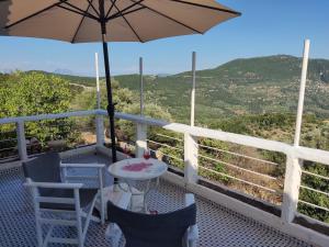 un patio con mesa, sillas y sombrilla en STATHIS GUESTHOUSE en Lefkada