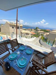 balcón con mesa de comedor y platos azules en Odysseus journey en Nikiana