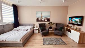 a bedroom with a bed and two chairs at Green Stone Apartment in Bydgoszcz